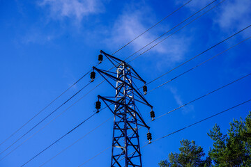 Looking up at a power pylon with blue sky background