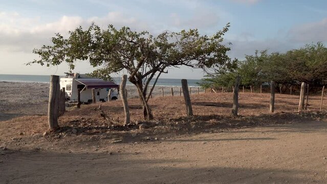 Camper van stationed at Popoyo Beach Nicaragua close to an access road, Wide handheld shot