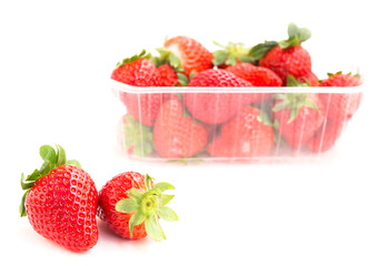 fresh appetizing strawberries in a plastic tray onwhite background