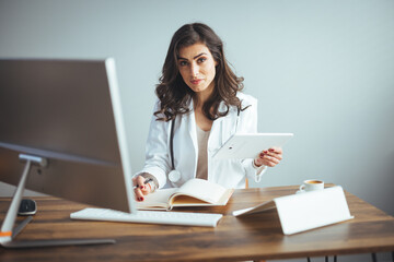 Confident female doctor sitting at office desk, health care and prevention concept. Portrait of...