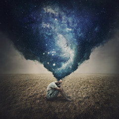 State of mind and mental health concept as a melancholic lone person seated in an open land suffers burnout. Dark smog comes out of man head and transforms into a galaxy of thoughts - obrazy, fototapety, plakaty