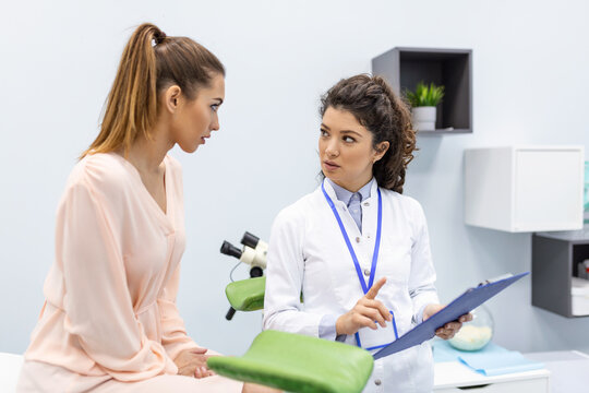 A gynecologist is examined by a patient who is sitting in a gynecological chair. Examination by a gynecologist. Female health concept.