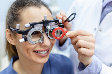Ophthalmologist examining woman with optometrist trial frame. female patient to check vision in ophthalmological clinic - obrazy, fototapety, plakaty