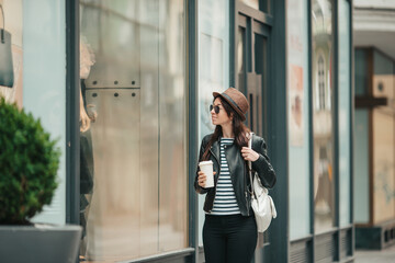 Fototapeta premium Happy young woman in hat on the street of european city.