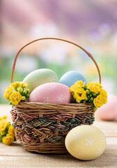 Easter eggs and flowers in a basket and on a wooden table