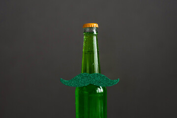 Green beer and lemonade in a bottle with a mustache. St. Patrick's Day.