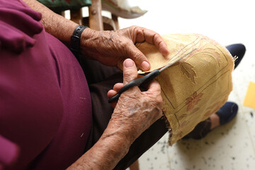 Seamstress cuts the fabric with scissors,view from above Tailor moves hands with scissors.Close up.