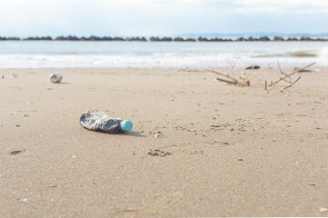 砂浜に落ちているペットボトルと缶とコピースペース