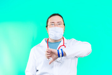 A doctor in a white coat and mask points his thumb down. The doctor shows a gesture of disapproval. Bracelet in the colors of the flag of Israel.