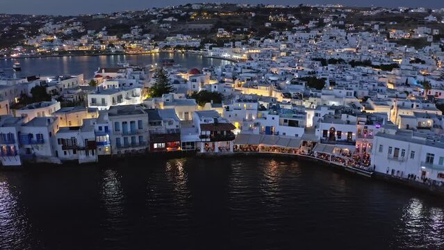 White greek traditional houses of Mykonos island with night illumination. Aerial