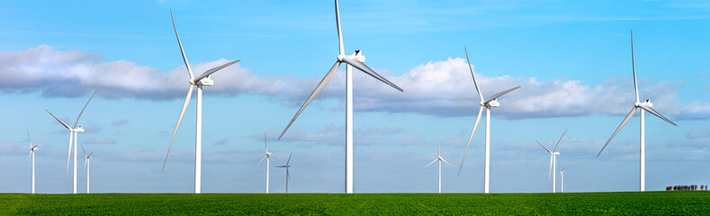 Panoramic view of a large field of wind turbines in operation.
