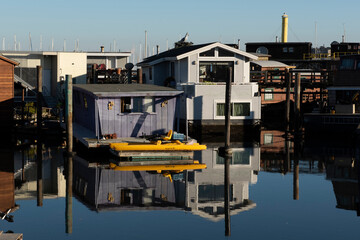 Fototapeta na wymiar Colorful wooden house boats reflected into the still water of Richardson Bay in Sausalito, California.