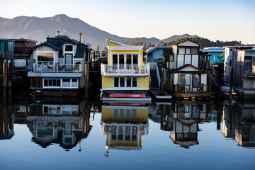 Colorful wooden house boats reflected into the still water of  Richardson Bay in Sausalito,...