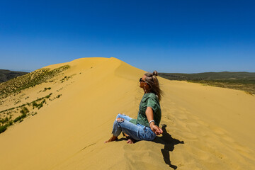A girl on the sand dunes of Sarykum. The desert in Dagestan. Russia. 2021.