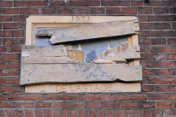 Amsterdam Canal House Facade Detail with Stone Tablet Depicting a View of Nieuwmarkt Square Partially Covered with Wooden Planks, Netherlands