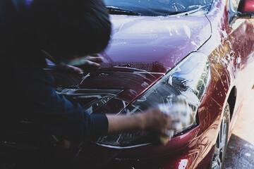 
Car detailing - the man holds the microfiber in hand and polishes the car. Selective focus.