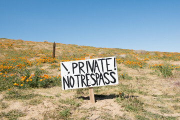 No Trespass Sign at the edge of a poppy field. 