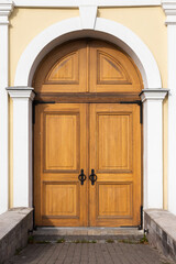 Old wooden door in yellow wall, background texture