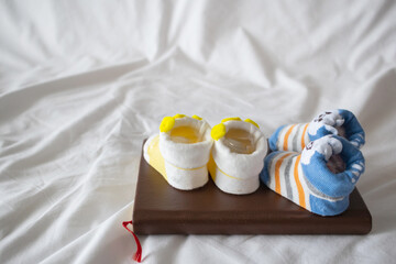 Soft Focus and Smooth Focus,Two pairs of newborn shoes laying on a book in the expectant mother's bedroom are the shoes of the baby that she bought for her baby and was waiting to see her baby's face.