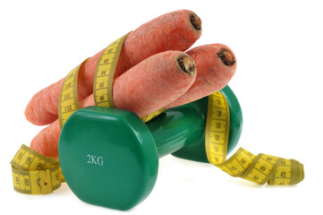 Concept de régime carottes avec une haltère et un mètre souple sur fond blanc