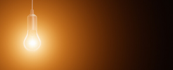 electric incandescent lamp on a black background with an orange halo