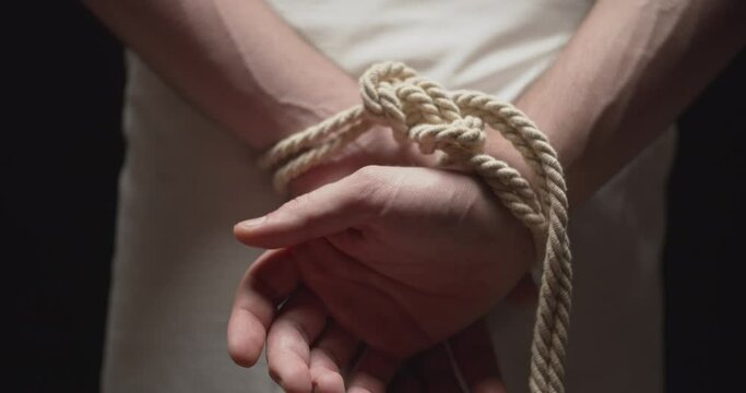 Man with the hands tied by a rope dropping three arrows