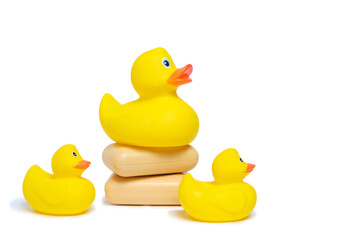 Three yellow rubber ducklings and two pieces soap white background.Bathing baby and cleanliness.