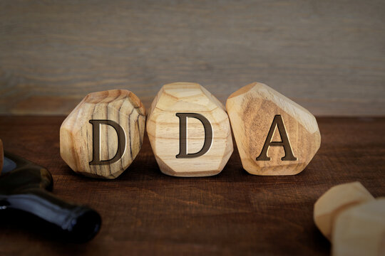 DDA letters written on wooden blocks. Dorosle Dzieci Alkoholikow (polish term for Adult Children Of Alcoholics) concept.