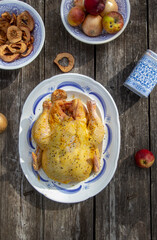 Preparing chicken with onions, apples and spices for baking.