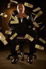 Crime pays when youre in control. Mob boss seated on a chair with banknotes blowing all around him.