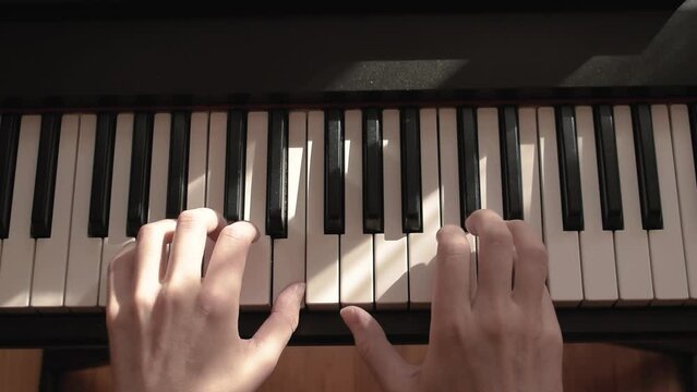 Close-up of pianist's hands play electric piano