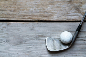 golf ball and golf club on wooden table background, sport concept