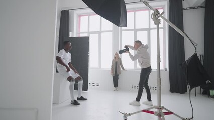 photographer is capturing professional football player with ball in studio, content for magazine - Powered by Adobe