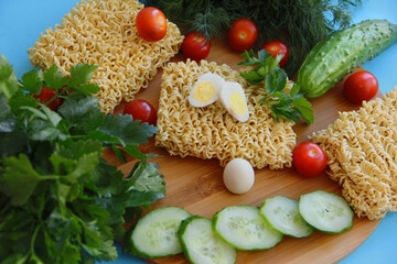 Instant pasta with fresh vegetables on a wooden background
