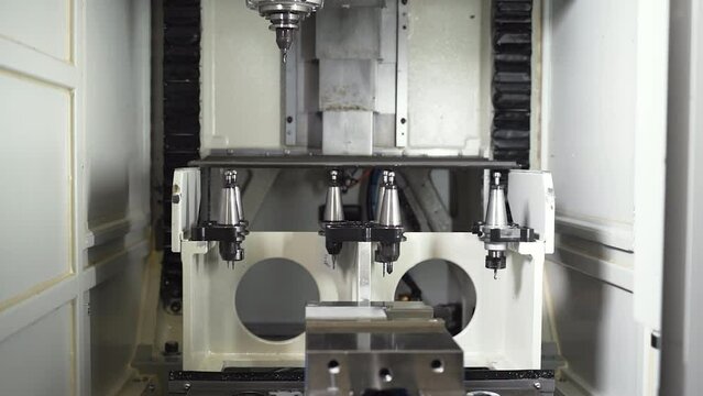 Automatic CNC machine selecting detachable drill from ejected toolbox. 