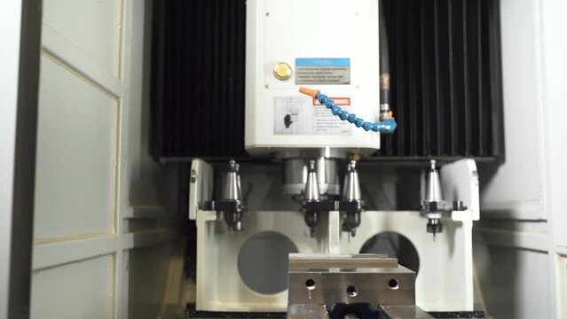 Automatic CNC machine ejecting a drill extension, putting it in a rack.