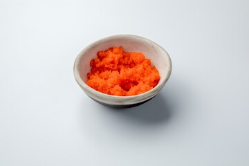 ceramic gravy boat with flying fish caviar tobiko on a white background