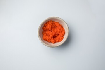 ceramic gravy boat with flying fish caviar tobiko on a white background
