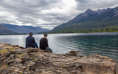 Father and son contemplating the scenery of a beautiful lake