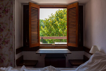 Room with bed and open wooden shutters