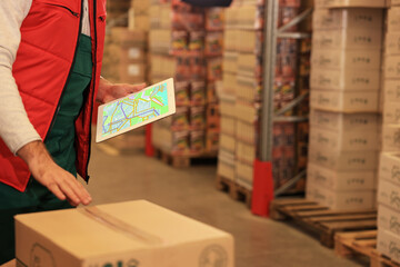 Man with tablet working at warehouse, closeup. Logistics center