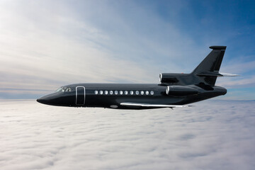 Black modern luxury executive business jet flies in the air above the clouds - obrazy, fototapety, plakaty