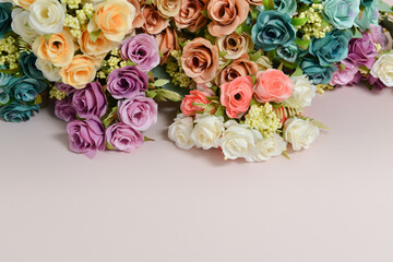 spring flowers, different colors roses on a pale pink background, free space for text, elegant spring composition, flower frame