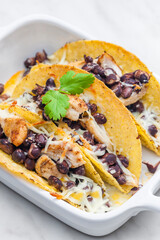 tacos filled with grilled chicken meat, red beans and grated cheese