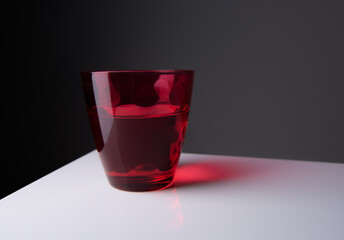 Red water glass over a black background.vintage glassware