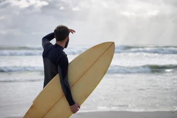 Hitting the beach. A surfer with his surfboard at the beach.