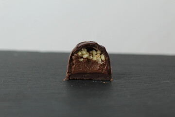 incision chocolate case candy stuffed with chocolate pralines and crushed peanuts close-up on a gray background with space for copyspace text. Chocolate Day Sweet Homemade Desserts