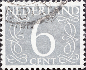 Netherlands - circa 1954 : a postage stamp from the Netherlands , showing a numeral framed with ornaments. Text: 6 cent, grey