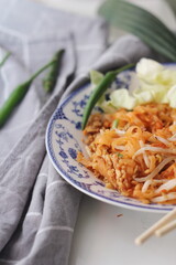 Thai food Pad Thai (national dish) served in a Chinese-style patterned bowl. Place it on a white table.