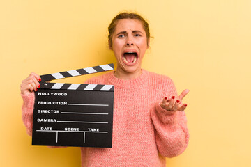 young pretty woman looking desperate, frustrated and stressed. cinema clapper concept